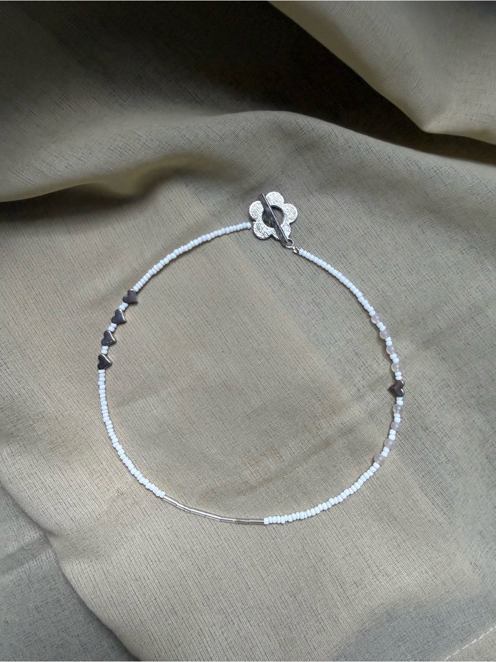 Delicate White Beaded Necklace with Silver Accents and a Flower Toggle Clasp